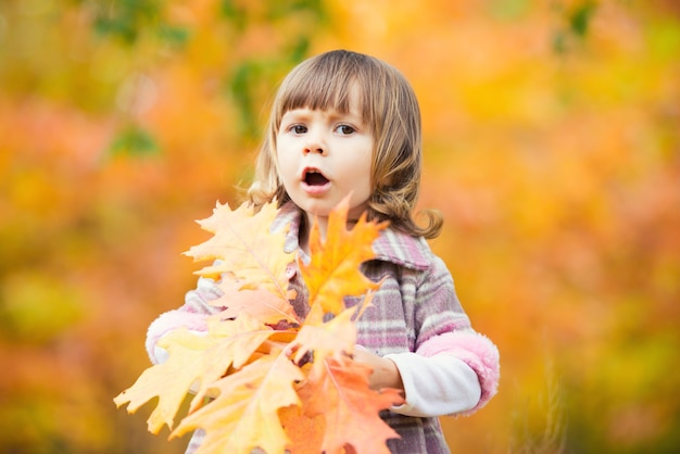 Happy little child, baby girl laughing and playing in the autumn on the nature walk outdoors.