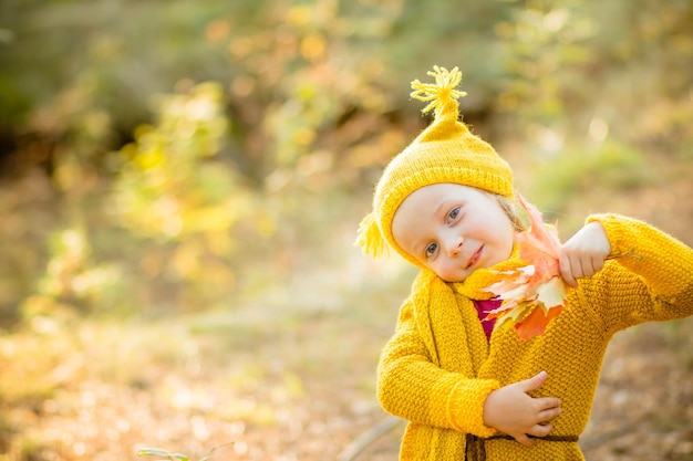 Happy little child girl 45 year old playing outdoor Girl is wearing warm jacket she is dancing jumpingspending a weekend in autumn park Autumnal moodChildhood Autumn season