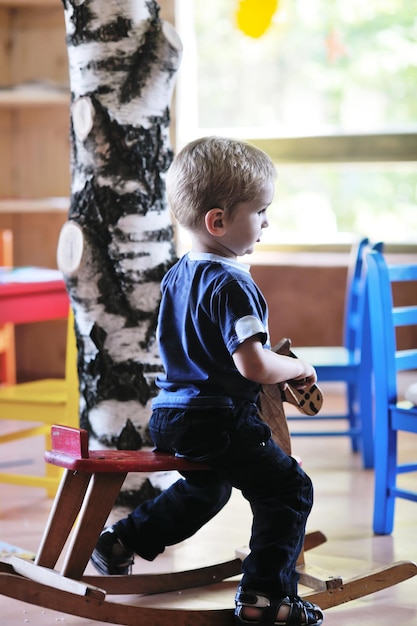 happy little child play game and have fun, education lessons in colorful kinder garden playground indoors