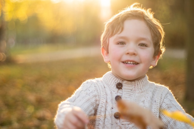 Happy little child playing in the autumn park