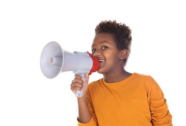 Happy little child speaking with a megaphone isolated on a white wall