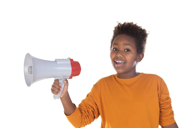 Happy little child speaking with a megaphone isolated on a white wall