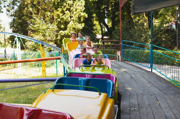 The happy little children are resting in the amusement park