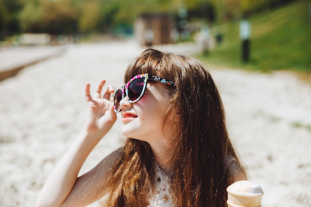 Happy little girl eating ice cream on the beach in summer summer vacation