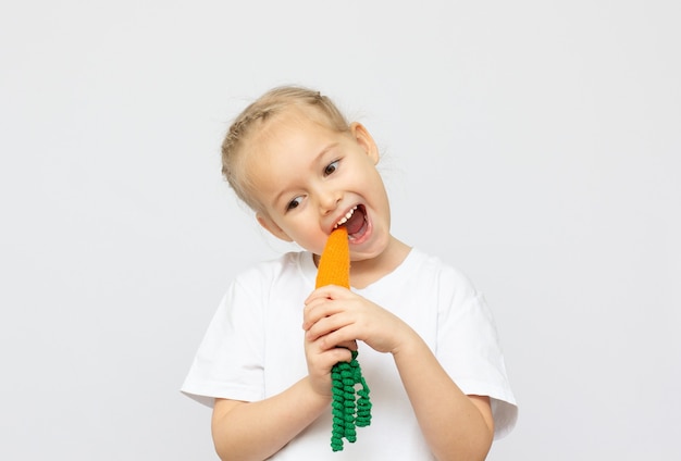 Happy little girl holding a knit carrot