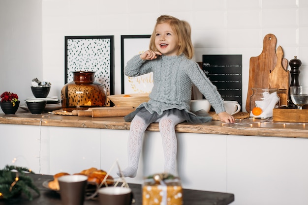 Happy little girl in kitchen at home. 