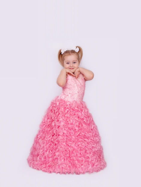 A happy little girl in a long pink dress