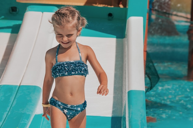 Happy little girl in the outdoor pool