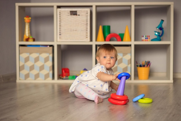 Happy little girl playing with toys at home in kindergarten or nursery Development of the child