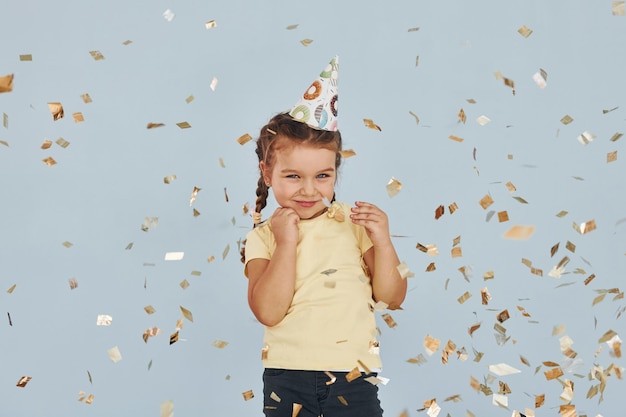 Happy little girl standing and have fun indoors at birthday party