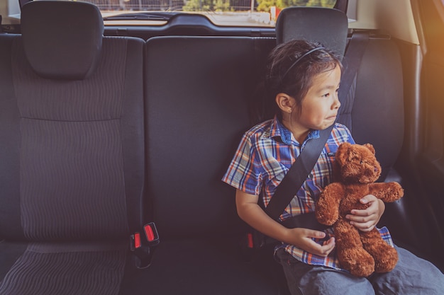 Happy little girl wearing seatbelts in car