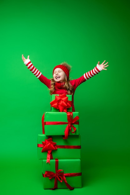 Happy little girl with a stack of Christmas gift boxes