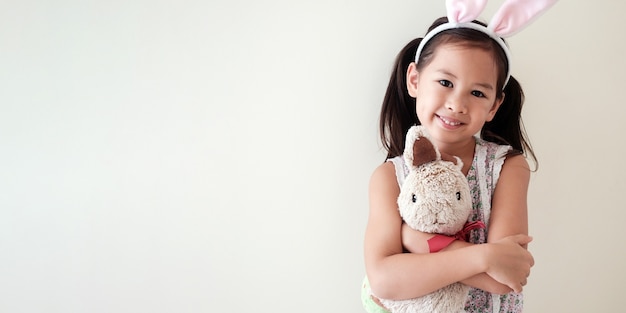 Happy little multicultural asain girl with bunny rabbit, Easter kid