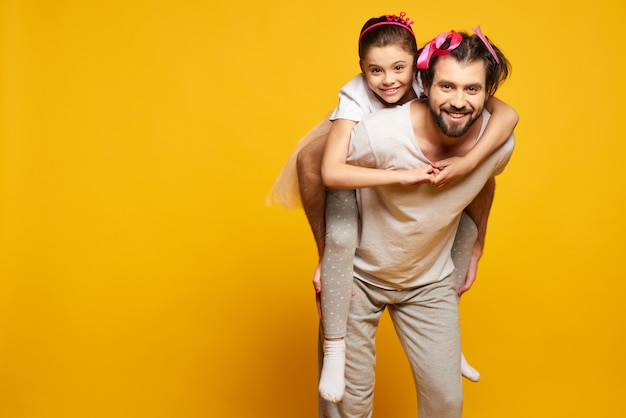 Happy Little Smiling Girl Is Riding on Fathers Back