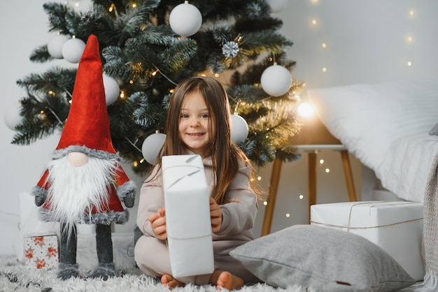 Happy little smiling girl with christmas gift box.