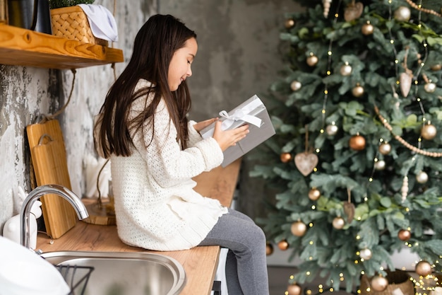 Happy little smiling girl with christmas gift box.