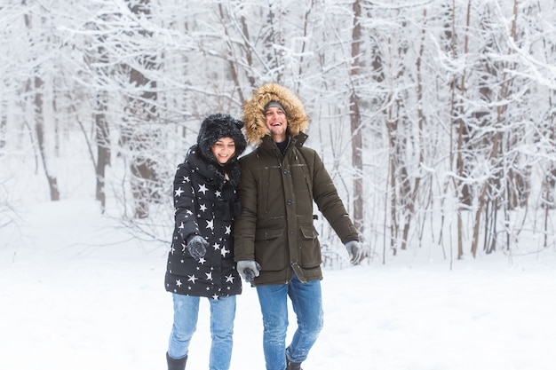 Happy loving couple having fun outdoors in snow park. Winter vacation.