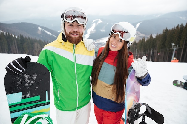 Happy loving couple snowboarders on the slopes frosty winter day