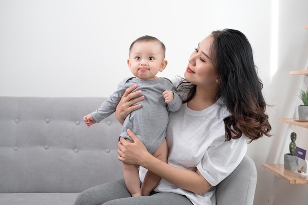 Happy loving family mother playing with her baby in the living room