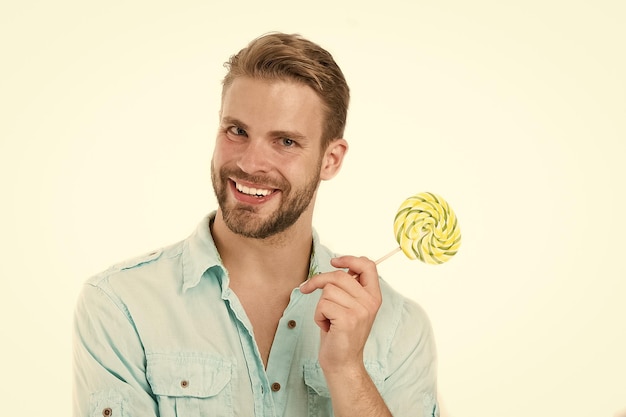 Happy macho with lollipop Man smile with candy on stick isolated on white background Food and snack Unhealthy diet and eating Lollipop fun