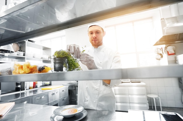 Photo happy male chef cooking at restaurant kitchen