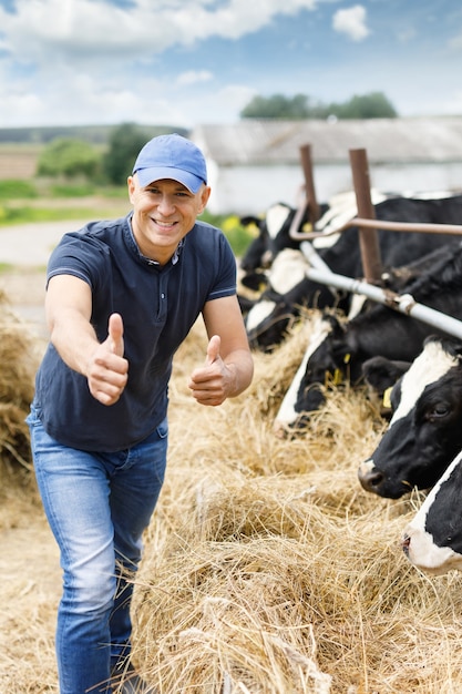 Happy male farmer among cows