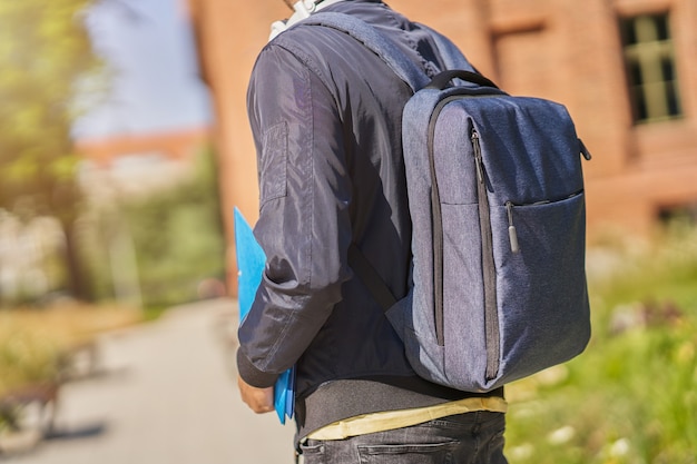 happy male student in the campus studying outdoors