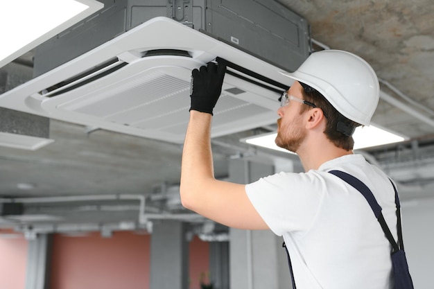 Happy Male Technician Repairing Air Conditioner