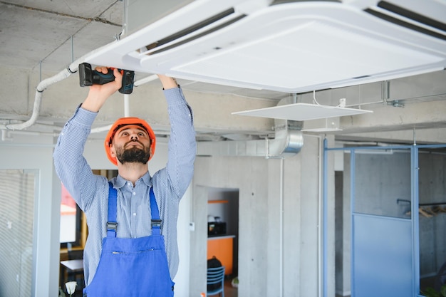 Happy Male Technician Repairing Air Conditioner