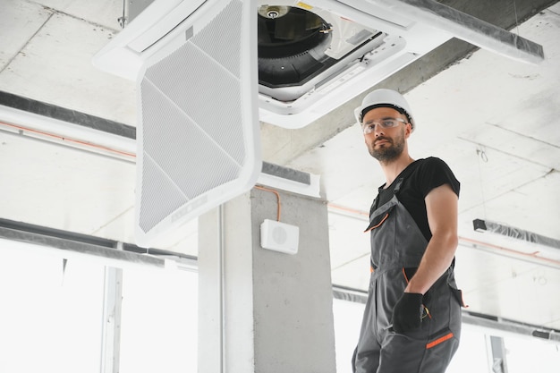 Photo happy male technician repairing air conditioner