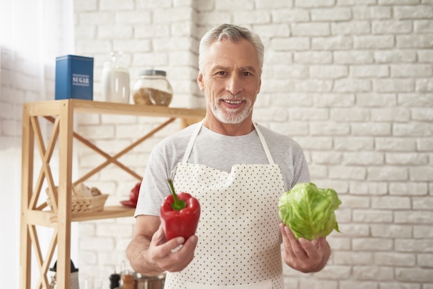 Happy Man in Apron Holding Vegetables in Hands.