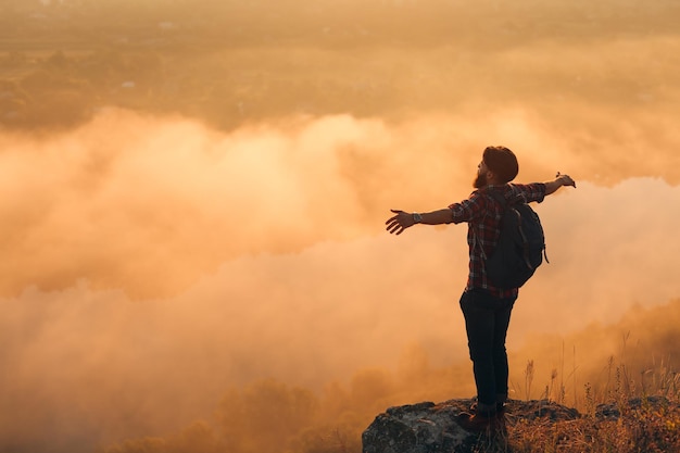 Photo happy man enjoying nature on rock at height