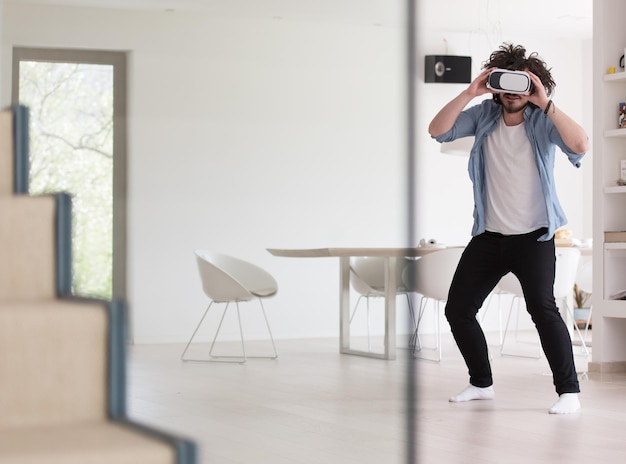 happy man getting experience using VR-headset glasses of virtual reality at home