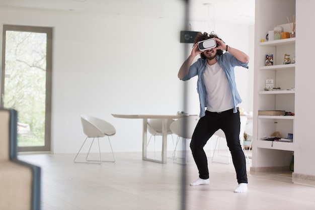 happy man getting experience using VR-headset glasses of virtual reality at home