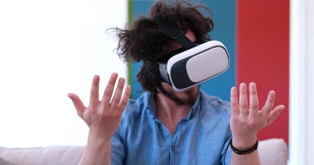 happy man getting experience using VR-headset glasses of virtual reality at home