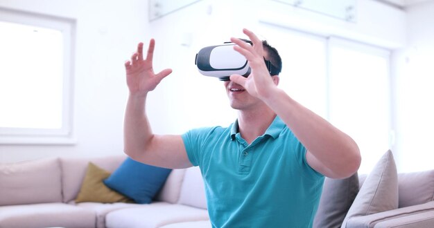 happy man getting experience using VR-headset glasses of virtual reality at home