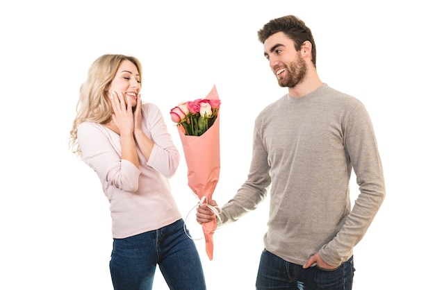 The happy man giving flowers for a girlfriend on the white background