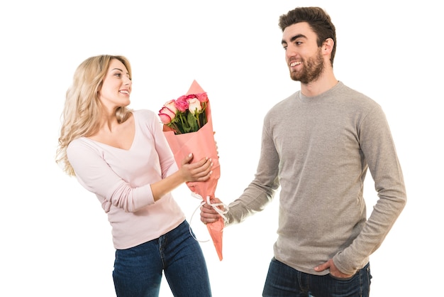 The happy man giving flowers for a woman on the white background