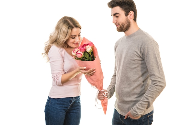 The happy man giving flowers for a woman on the white background