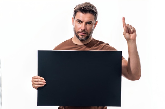 Photo happy man hold board thinking of idea on studio background portrait of man with board has many ideas man hold board with index fingers gesture man has idea blank board decision idea good idea