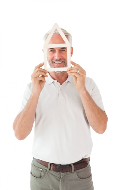 Photo happy man holding house outline over face on white background