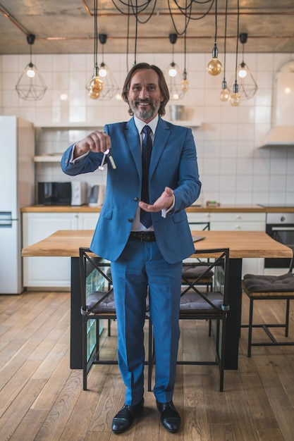 Happy man holding the key from new partment and looking excited