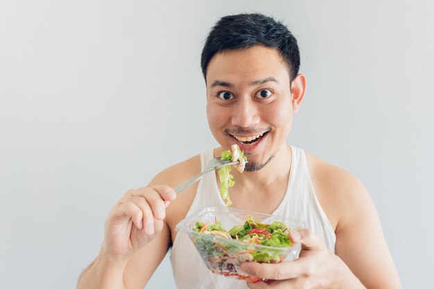 Happy man is eating healthy salad meal.