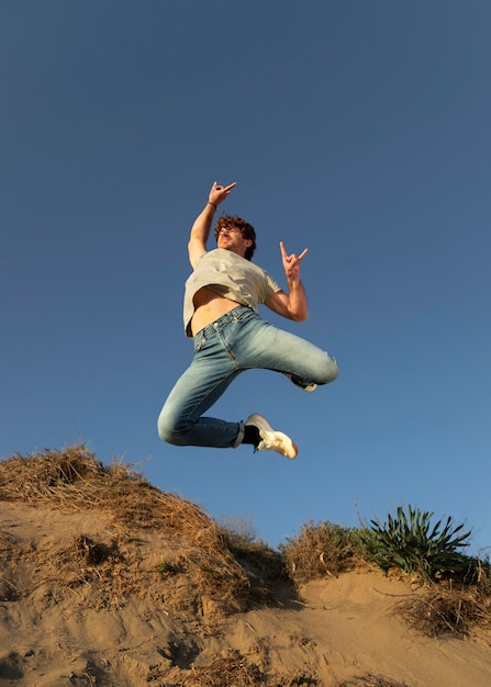 Happy man outdoors jumping up