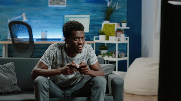 Happy man playing video games with controller on console