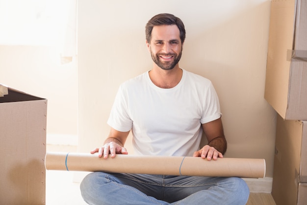 Happy man sitting surrounded by boxes