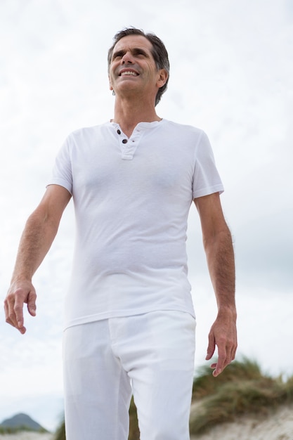 Happy man standing on beach