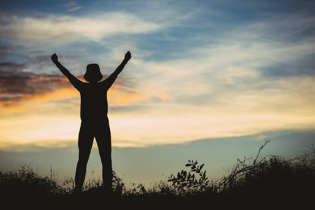 Happy man with open arms stand on the top of mountain celebrating success outdoor. People, success