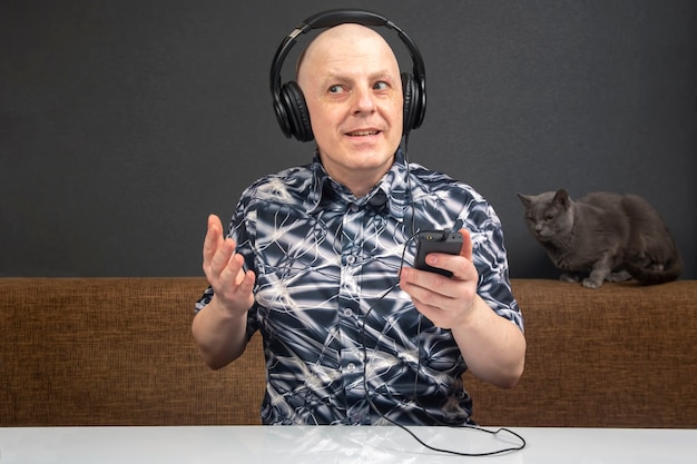 Happy man with in portable headphones listens to music using a player.