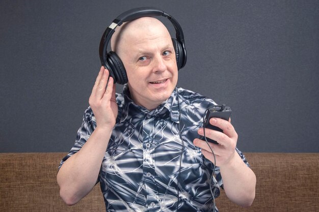 happy man with in portable headphones listens to music using a player.